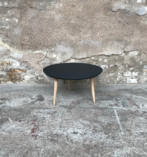 Table basse ronde avec le plateau noir et des pieds compas en chêne